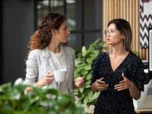 Two female employees walk in office