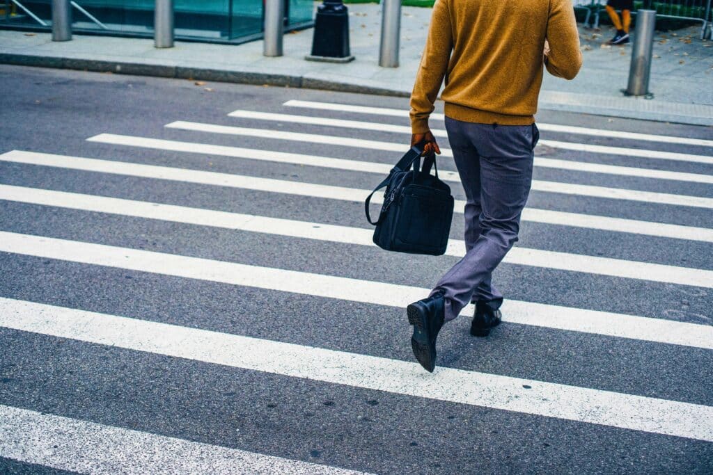 Man walks across the street at a zebra crossing