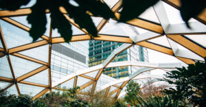 Woman in winter coat walking in hidden location at Canary Wharf, roof garden at Crossrail Place, London, UK