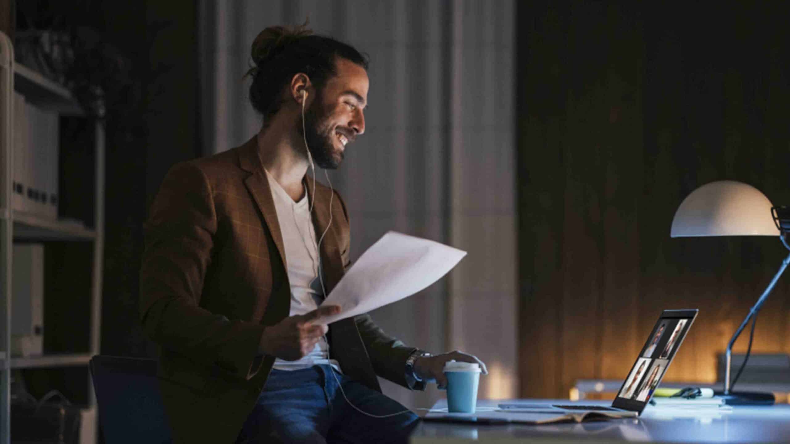 Smiley man wearing earphones on video call