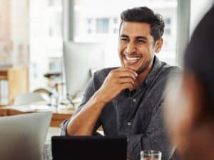 Shot of a young businessman smiling during a meeting with colleagues at work