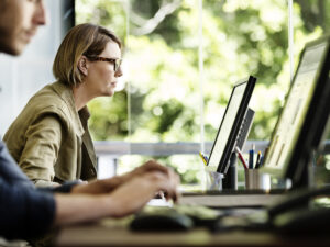 Colleagues at work at their desks, looking at computers