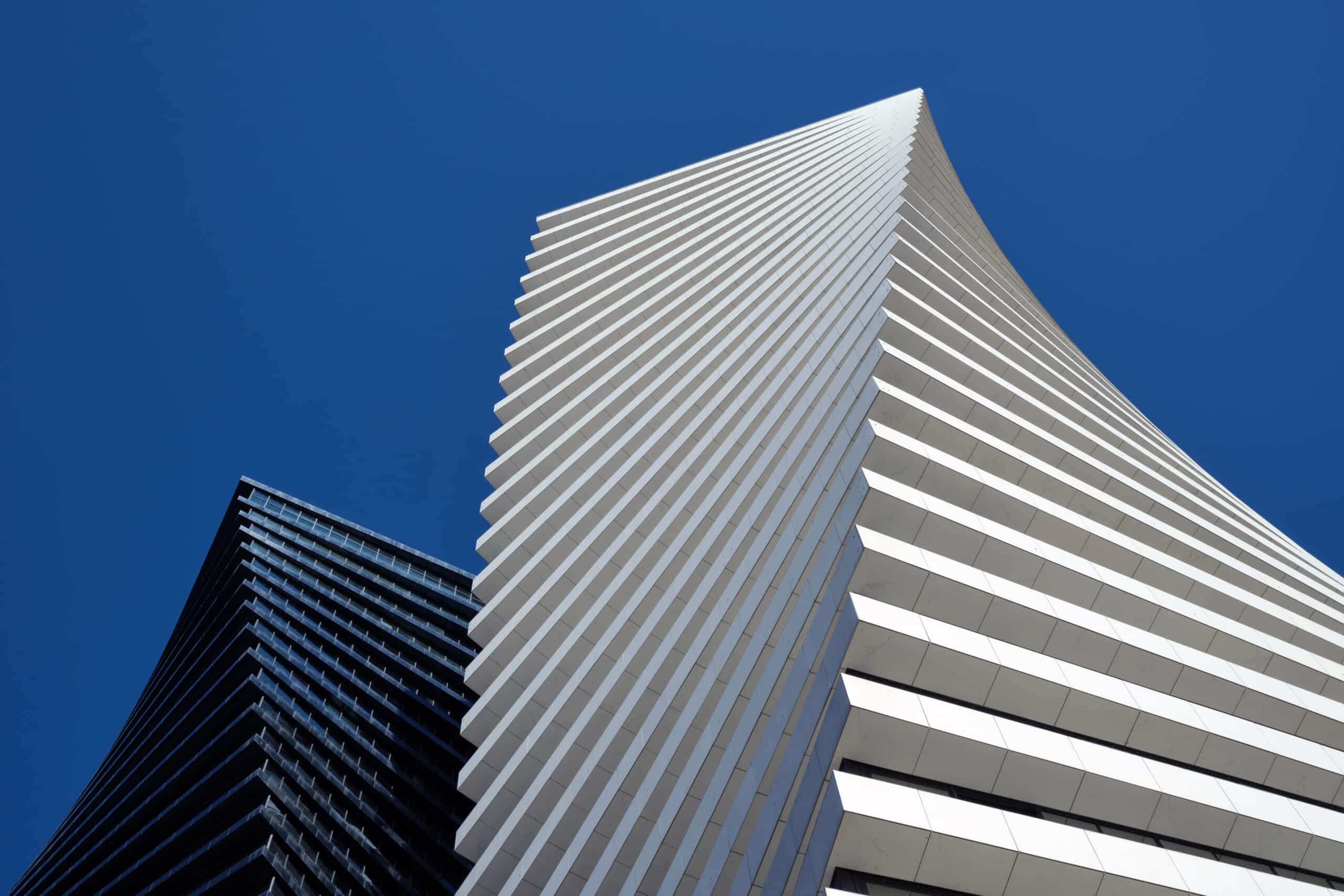 Bottom view of the black tower of skyscrapers Axis Towers Art Nouveau building against the backdrop of a beautiful clean sky