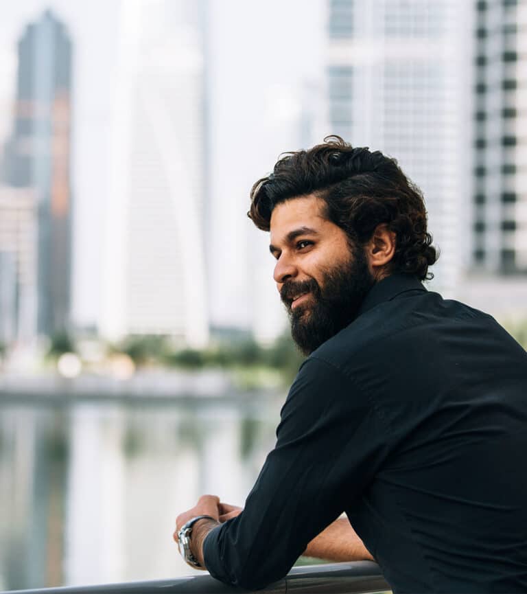 A Middle Eastern gentleman stands on the harbour of the legal district