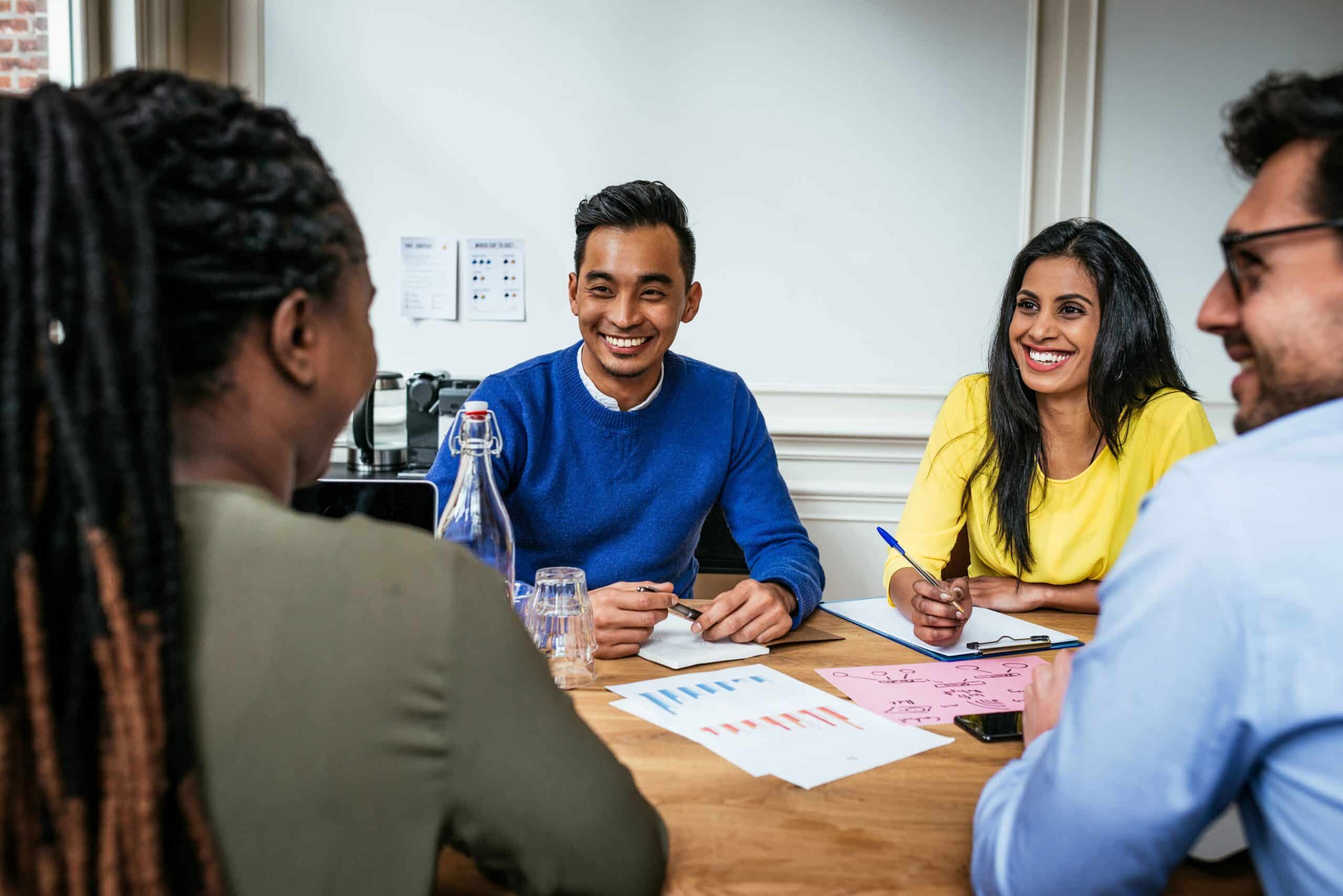 A group of people smiling in a meeting
