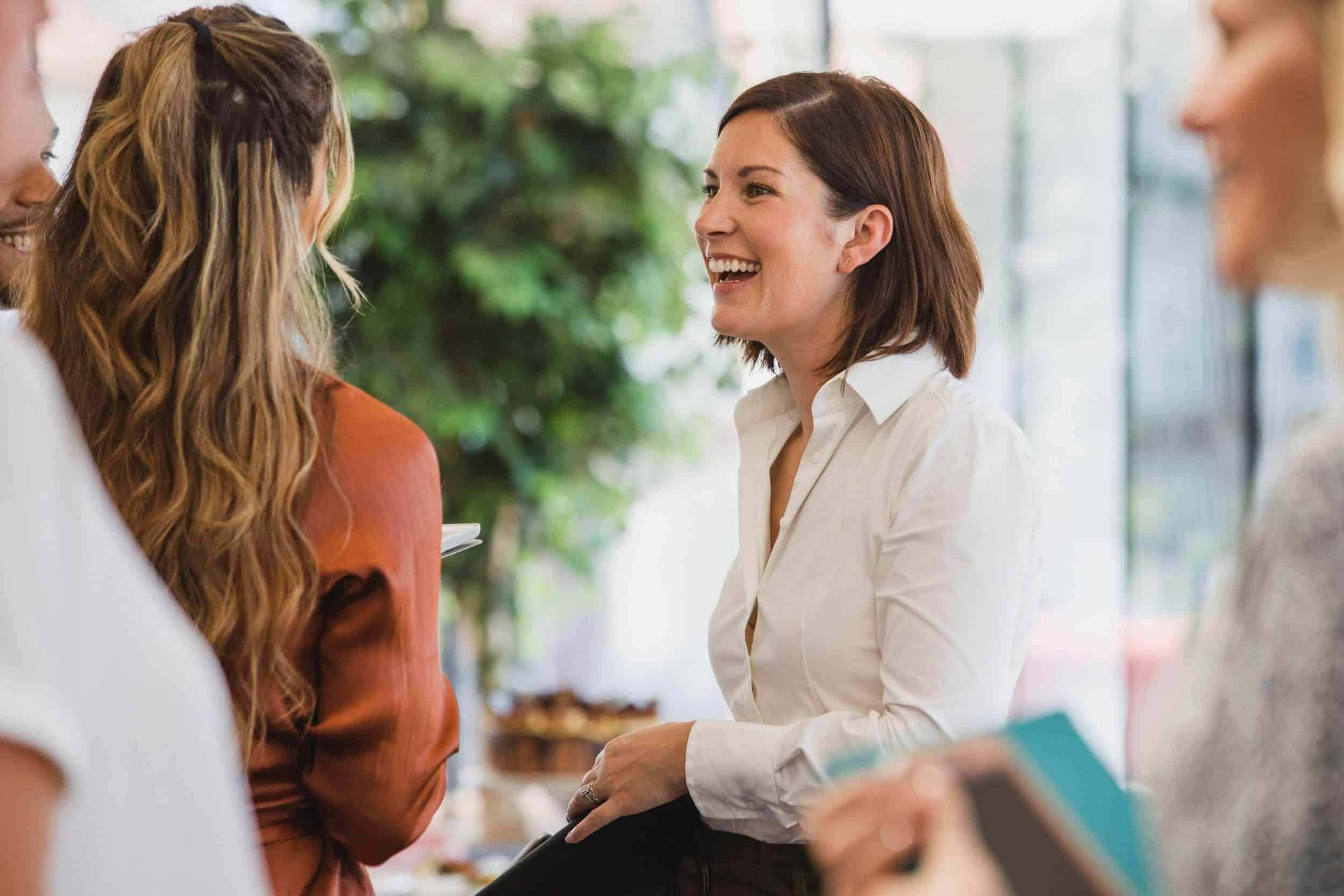 A group of people smiling warmly in a corporate setting