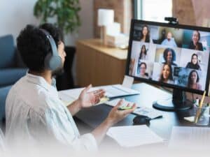 Video conferencing from home, the unrecognizable mid adult man leads a staff meeting with diverse employees.