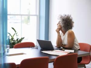 Middle aged woman looking out of the window in the boardroom