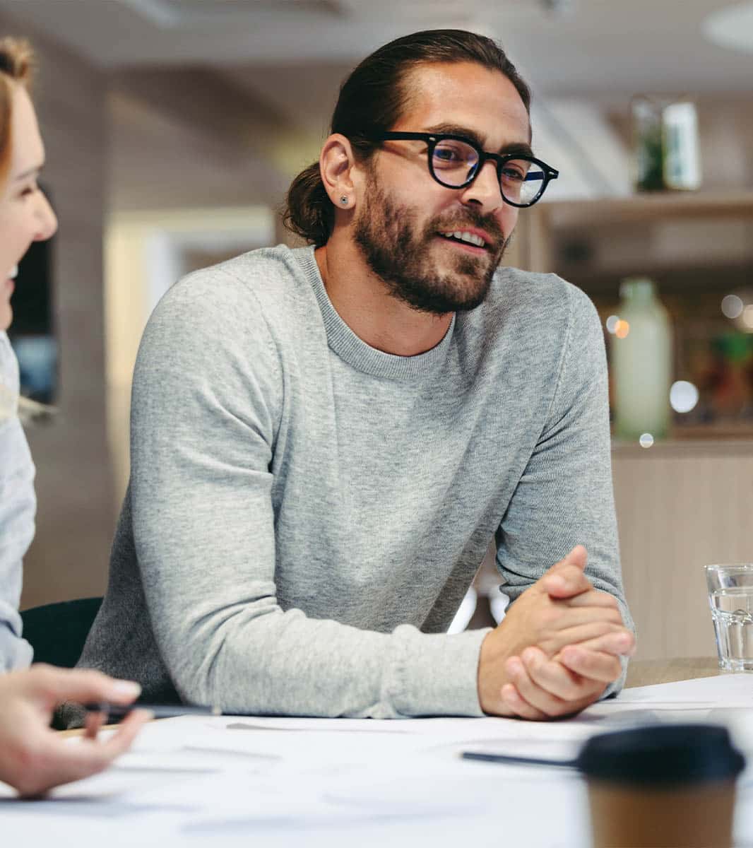 A company secretary recruiter sits at a desk in a meeting discussing salaries, benefits and reasons to hire