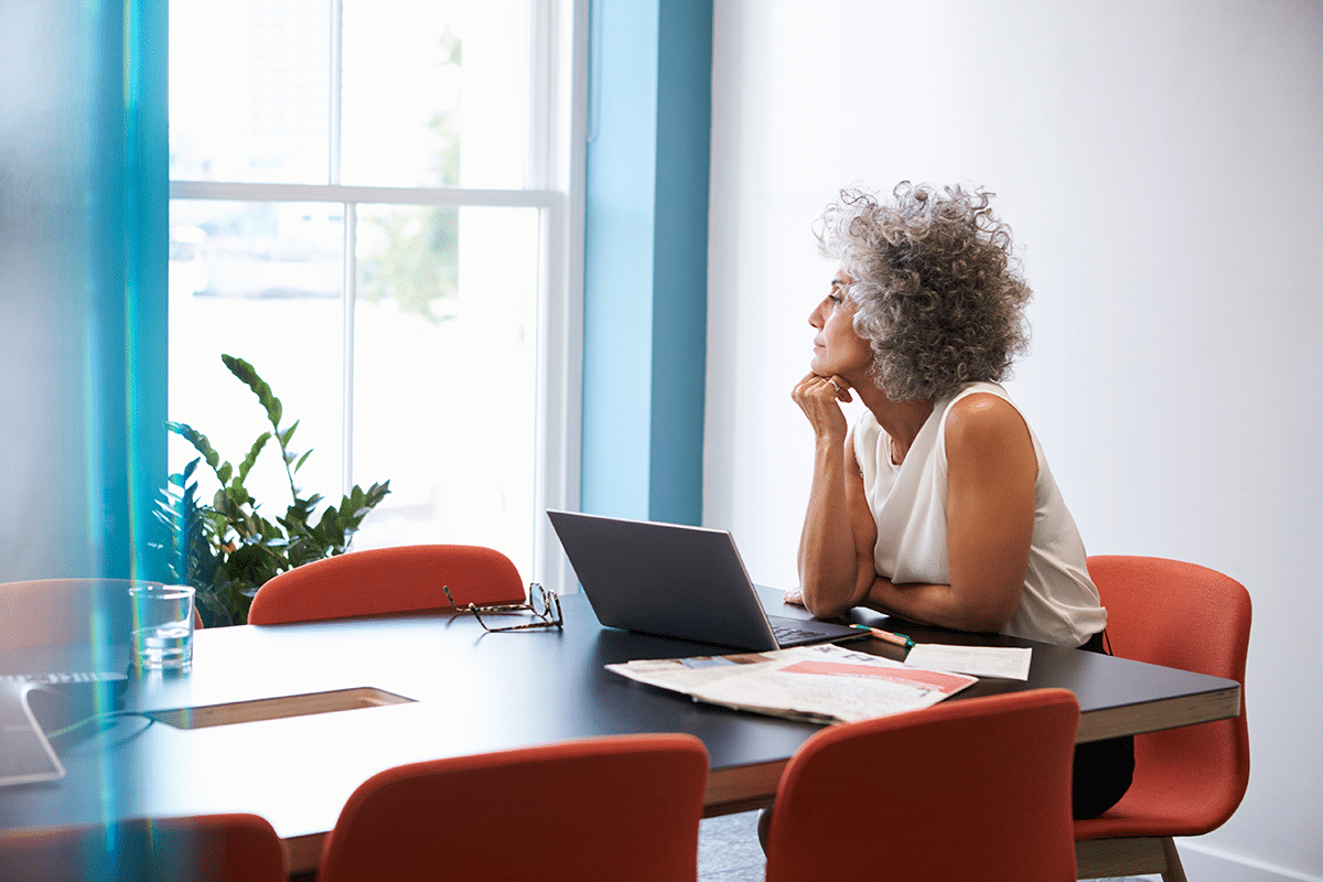 Women at desk staring out the window