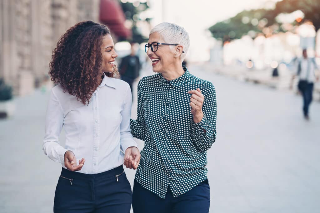 Two businesswomen walking together and talking