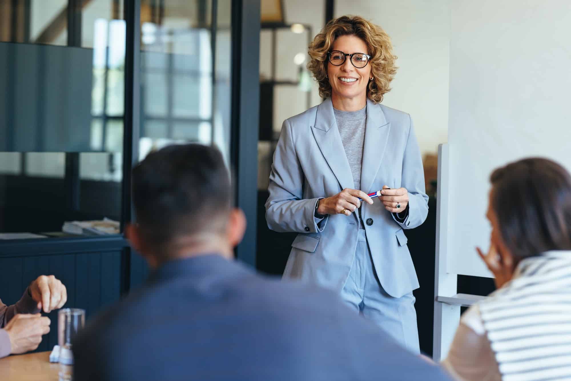 Female professional in blue suit presents at a meeting