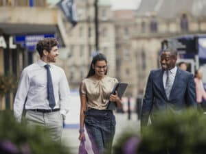 Three smartly dressed people walking and talking outside