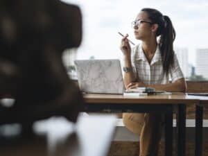 Casual woman working at wooden table