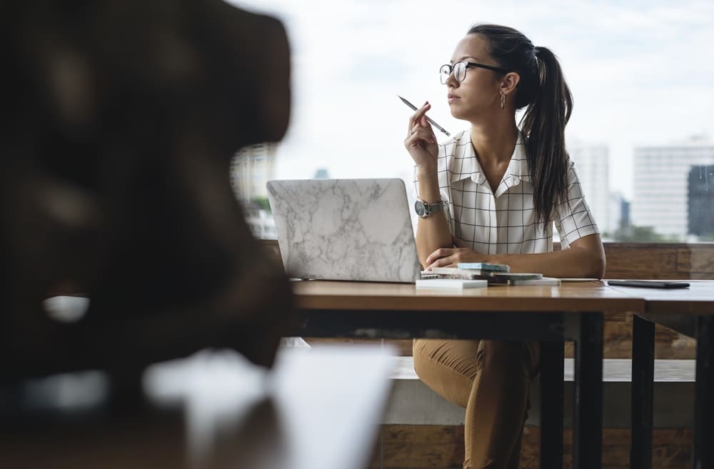 Casual woman working at wooden table