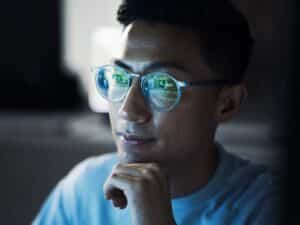 Asian man, developer and thinking in coding at night or programming software or application development. Male programmer or coder troubleshooting and working late on code in problem solving at office
