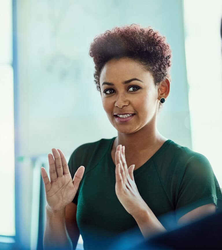 Close up of a woman at work, green shirt, making hand gestures