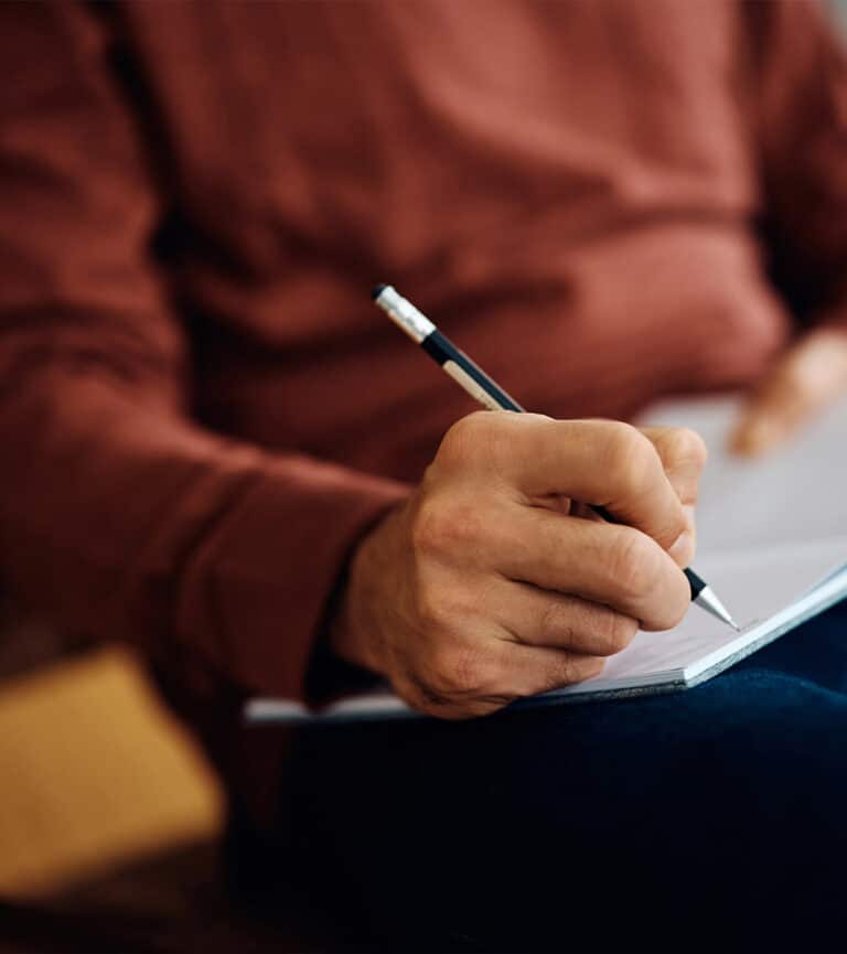 Close up of man writing notes in a notebook