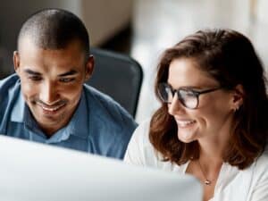 Shot of two young businesspeople sitting together in the office and using a computer