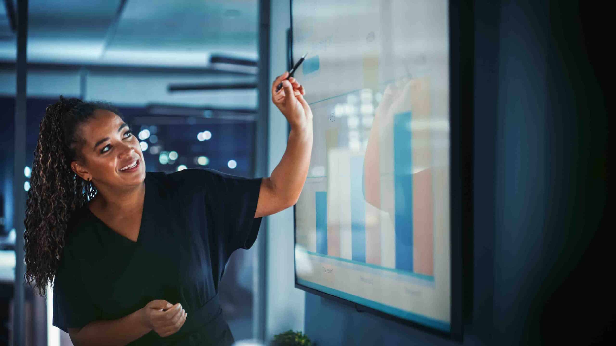 Woman pointing at screen presenting graph