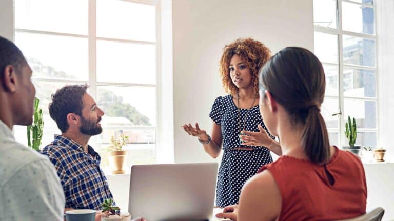 Woman presenting to colleagues in meeting room