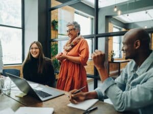Joyful group interacting around office table
