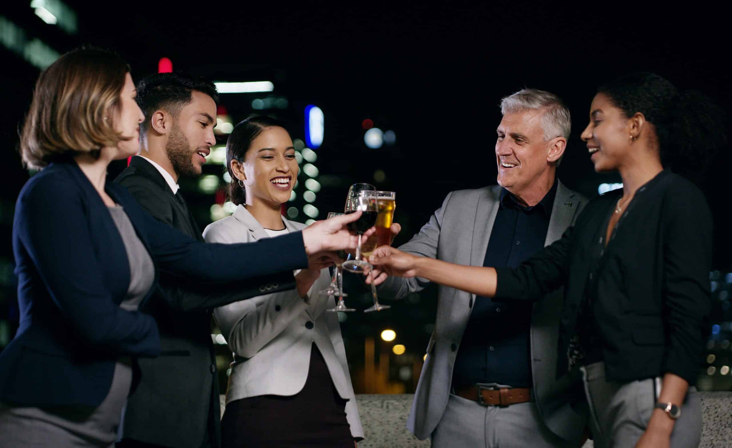 A group of business people cheering outside on a warm evening