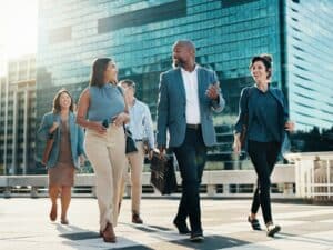 Meeting, walking and business people in city in discussion on morning commute, travel and journey. Corporate, teamwork and men and women in town talking for collaboration, partnership and career