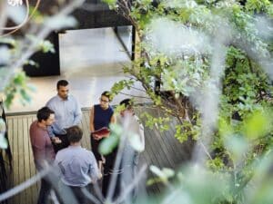 High angle view of business people discussing at lobby. Male and female professionals are in office. Focus is on executives at workplace.