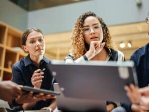 Female Manager Leading a Meeting About Sustainability and Ethnicity with her Multiethnic Teammates. Young Group of Employees Presenting Their Project Ideas To Startup CEO. Medium Shot